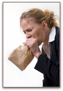 Woman having a panic attack, blowing into paper bag